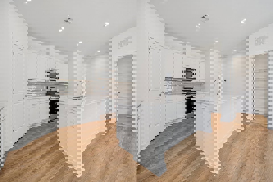 A kitchen with white cabinets.