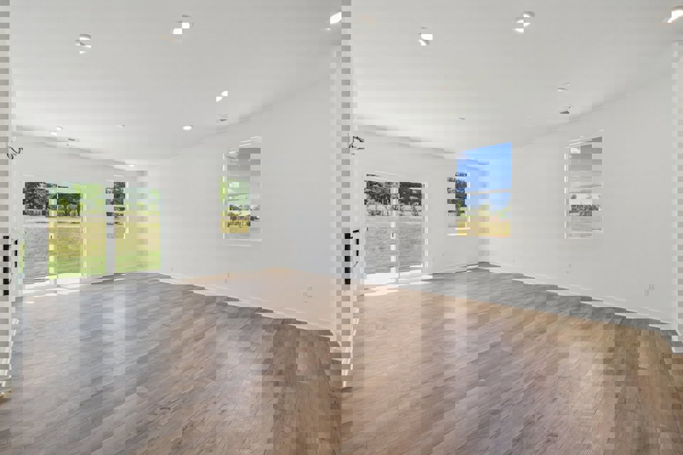 A room with a wood floor and a wood floor with a window.