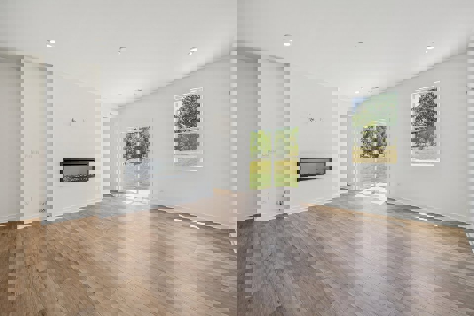 A room with white walls and a wood floor with a wood floor.