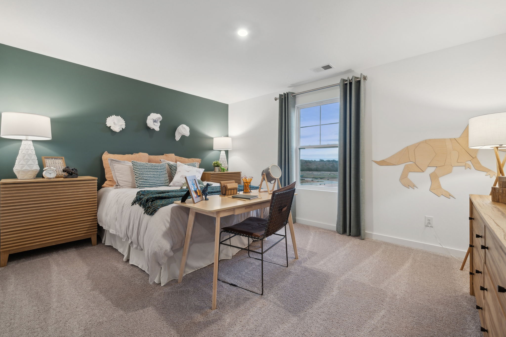 A bedroom with a bed desk and a chair.