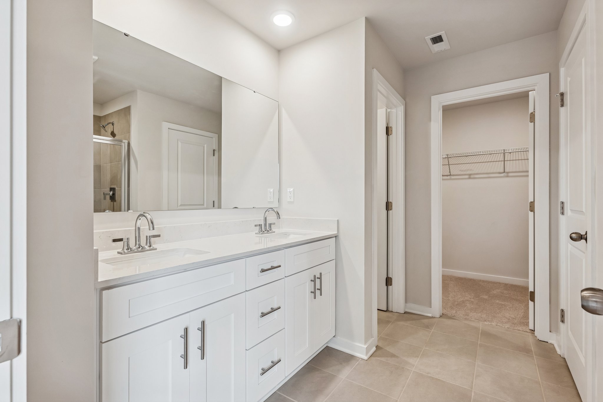 A bathroom with white cabinets.