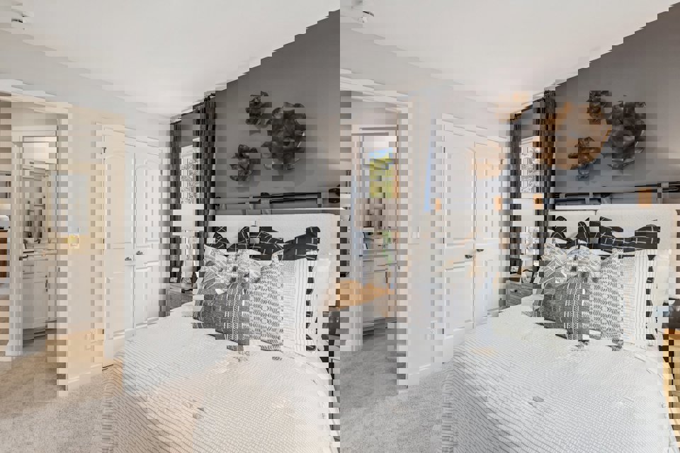 A bedroom with a bed and a lamp.