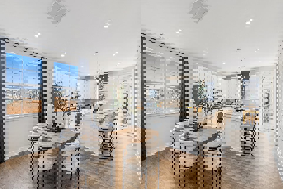 A kitchen with a dining table and chairs.