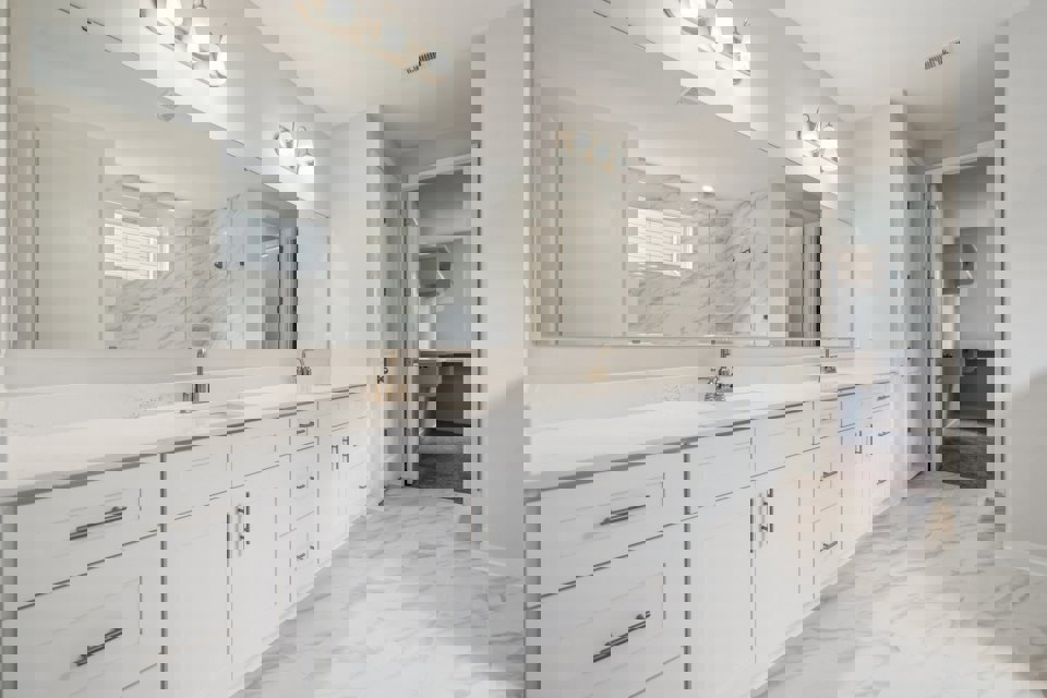 A bathroom with white cabinets.