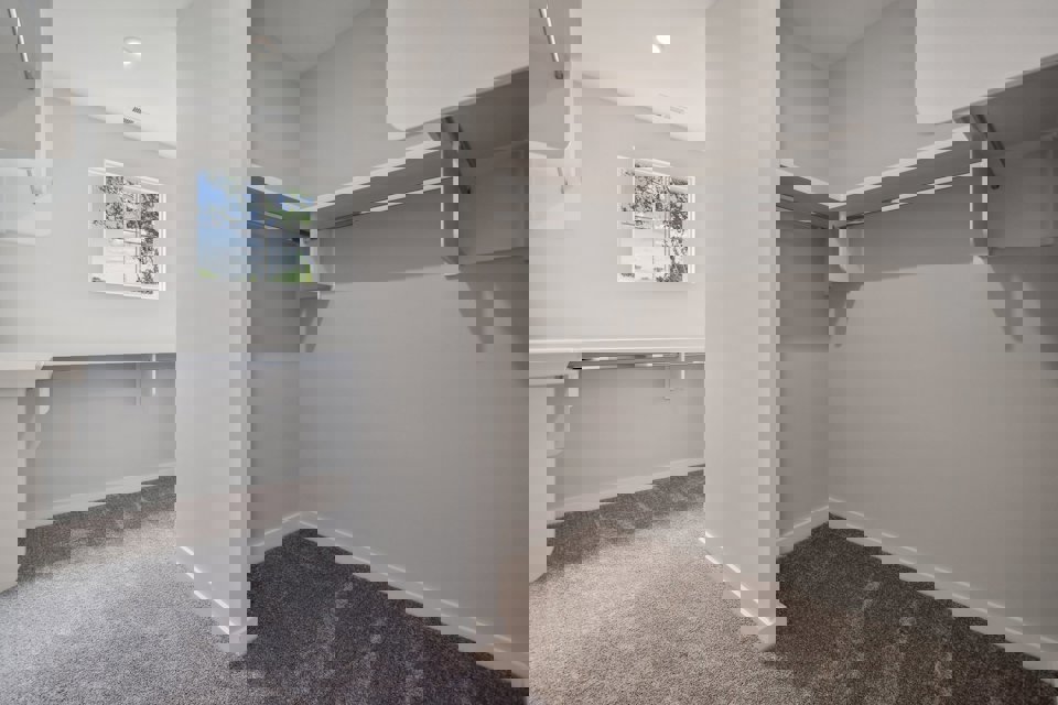 A room with a window and a white wall.