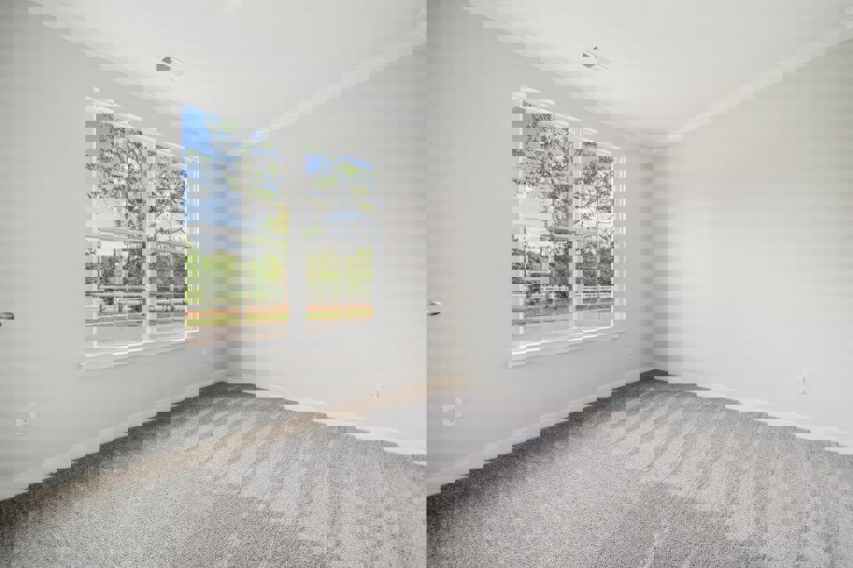 A room with a window and a white wall.