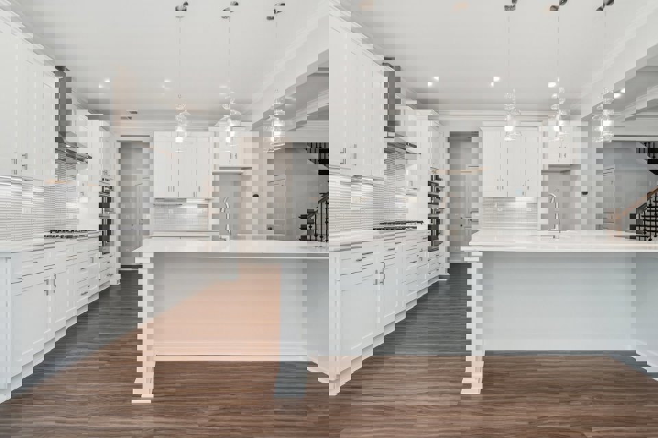 A kitchen with white cabinets.