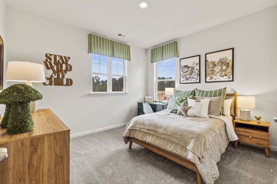 A bedroom with a bed and a desk.
