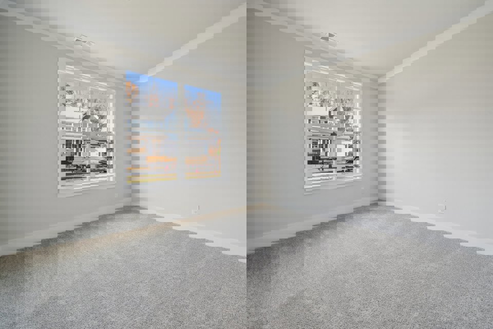 A room with a window and a carpet.