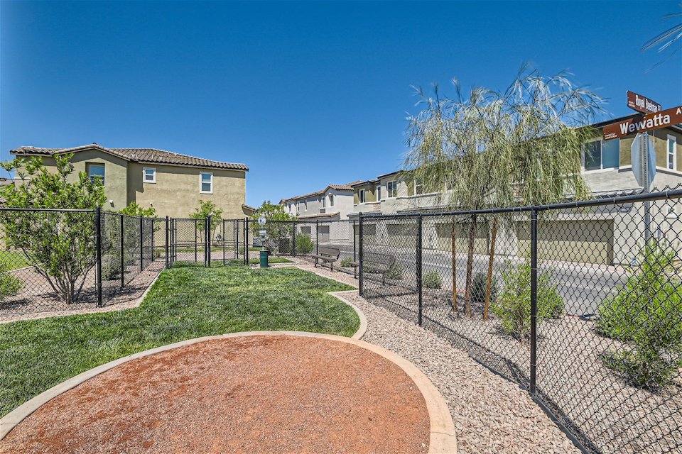 A fenced in yard with a brick path and a building.