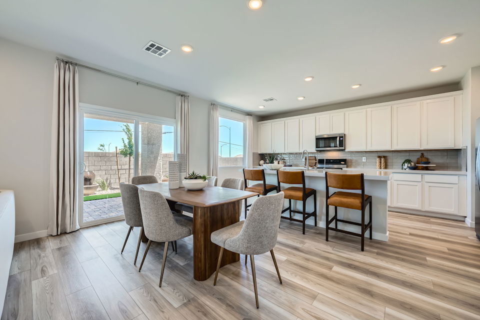 A kitchen with a dining table and chairs.