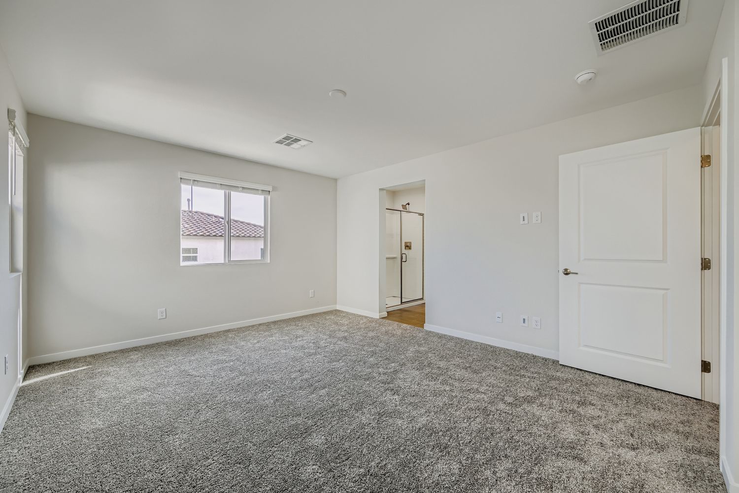 A room with white walls and a window.