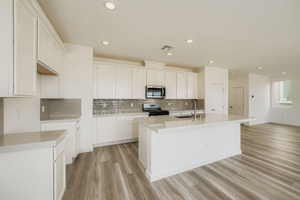 A kitchen with white cabinets.
