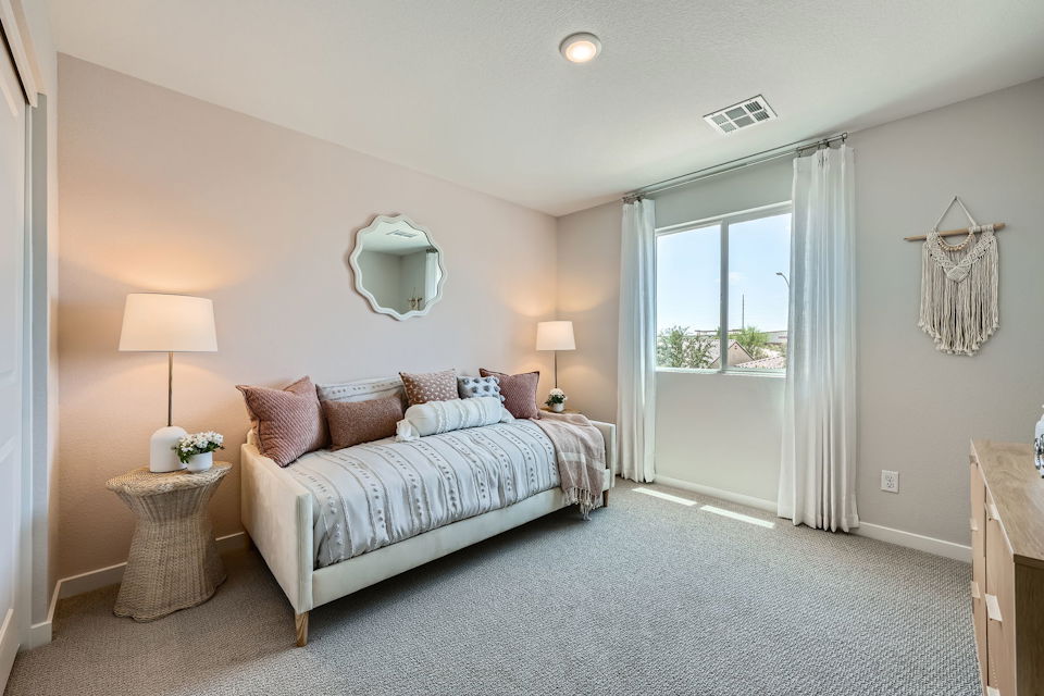 A bedroom with a bed and lamps.