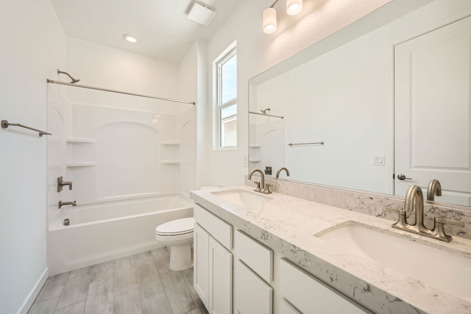 A bathroom with a tub sink and toilet.