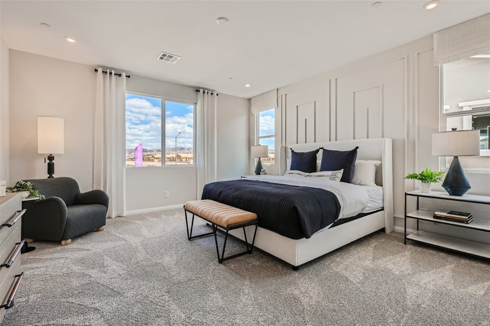 A bedroom with a bed and a chair.
