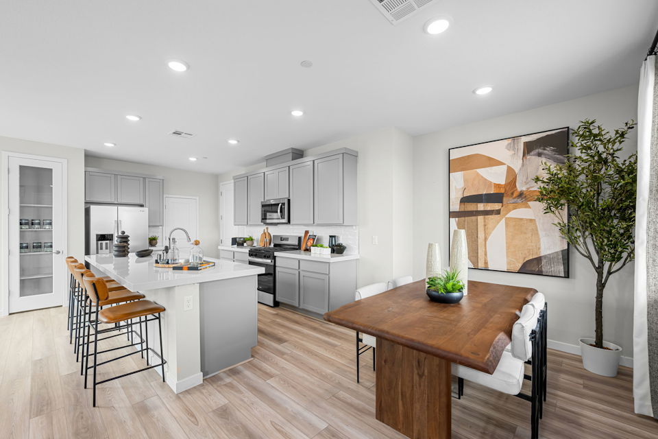 A kitchen with a table and chairs.