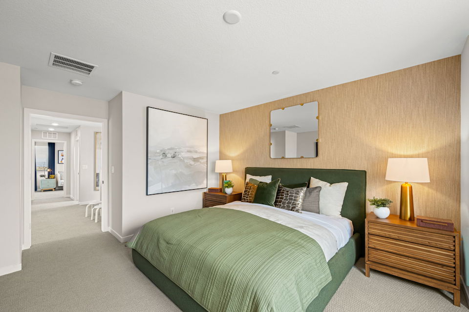 A bedroom with a bed and lamps.