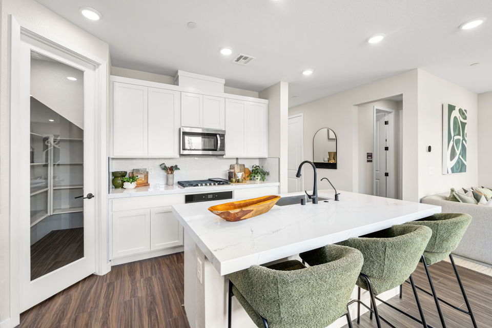 A kitchen with white cabinets.