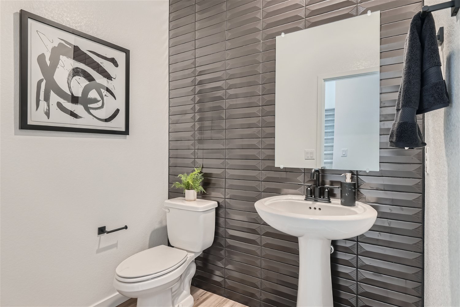 A bathroom with a sink toilet and a mirror.