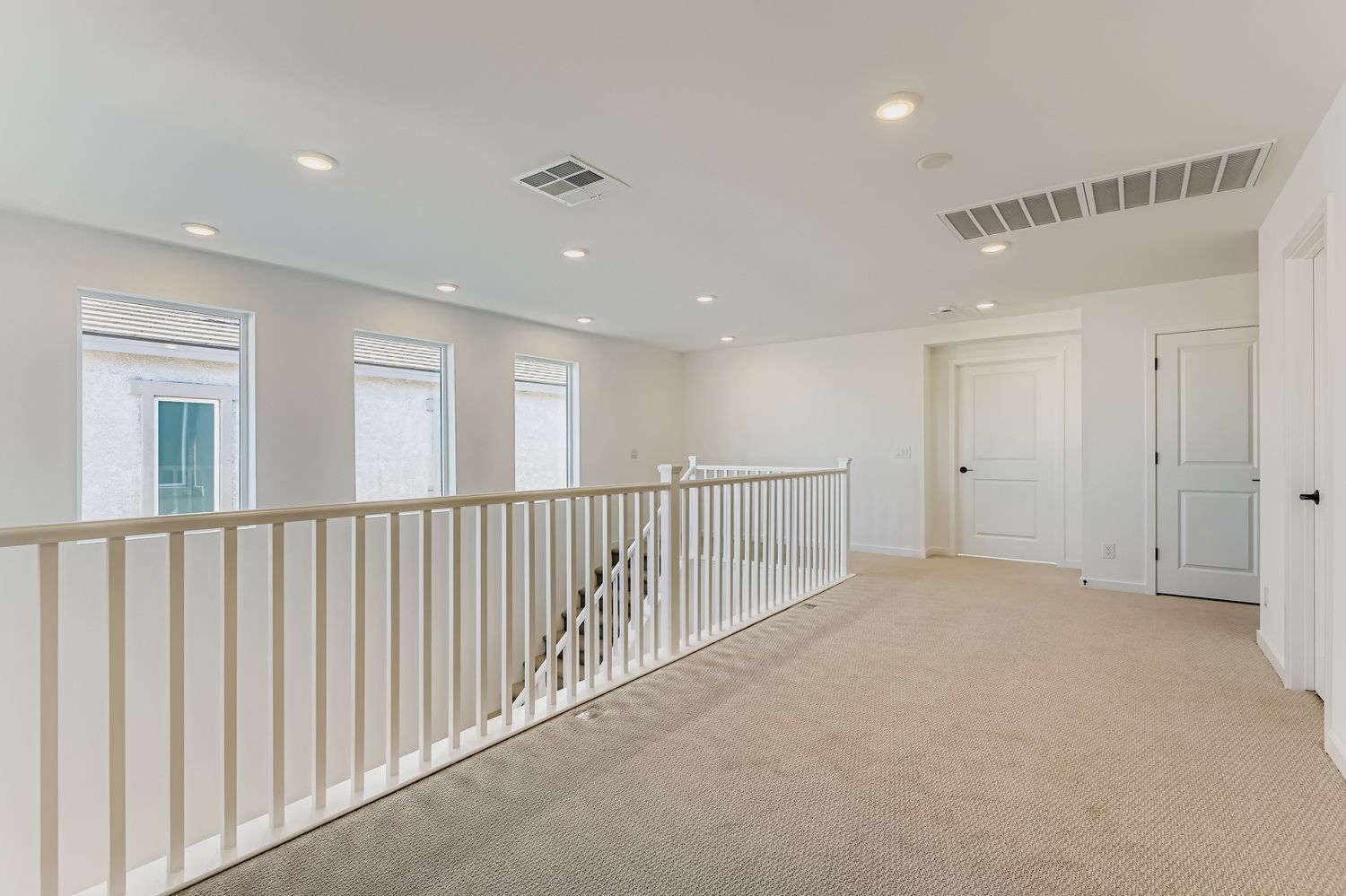 A room with white walls and a white railing.
