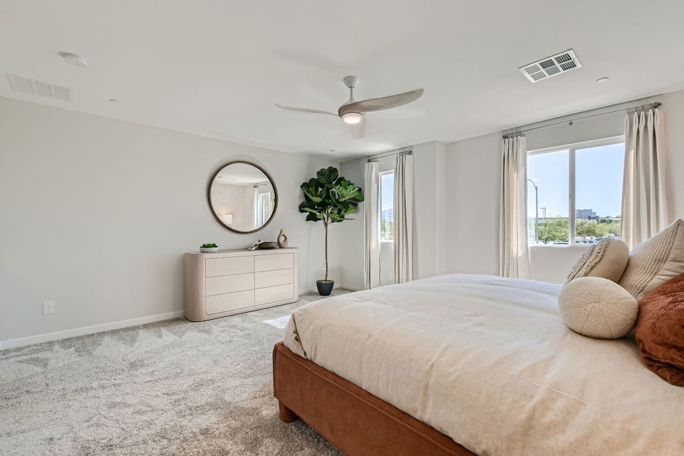 A bedroom with a bed and a mirror.