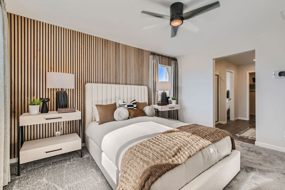 A bedroom with a bed and a fan.