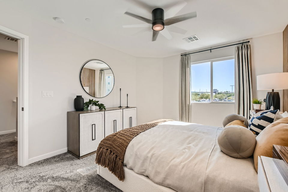 A bedroom with a large mirror.