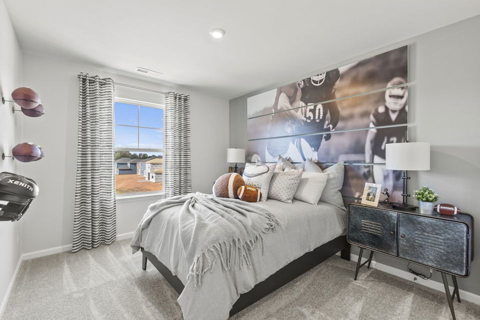 A bedroom with a bed and a table.