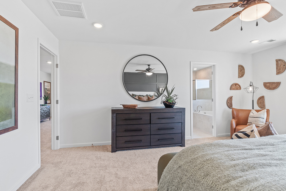 A bedroom with a large mirror.