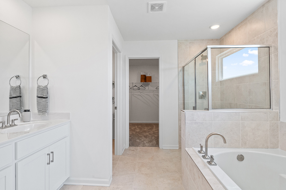 A bathroom with a tub sink and mirror.