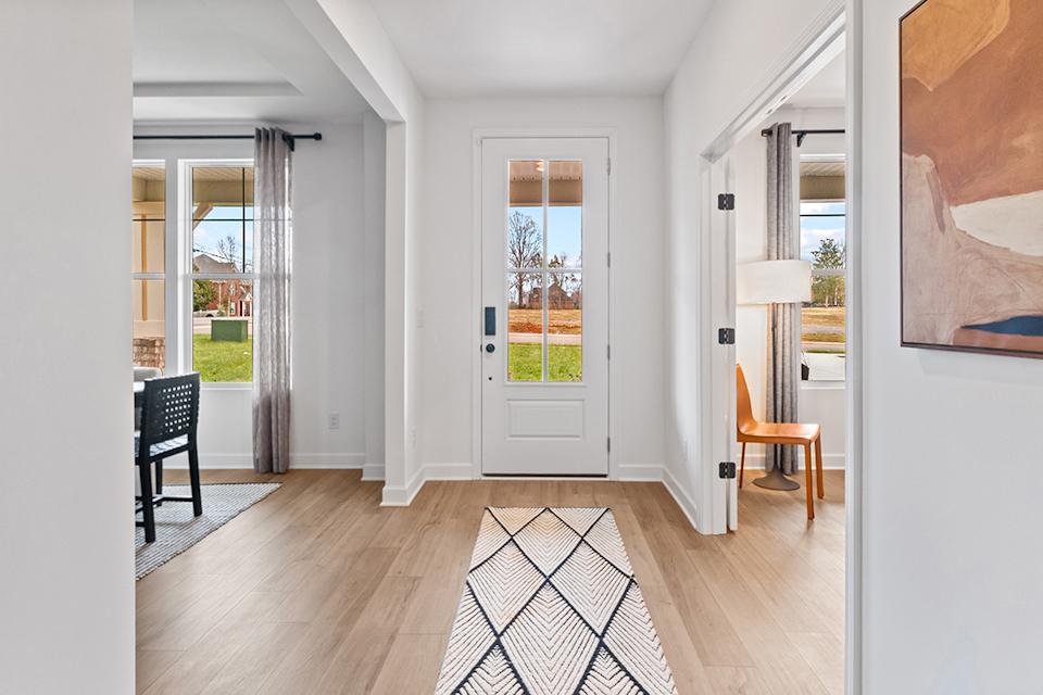 A room with a wood floor and a rug and a rug.