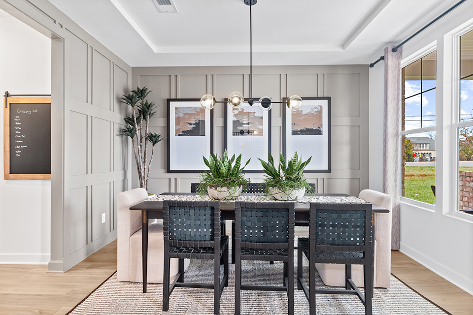 A dining room with a large table and chairs.