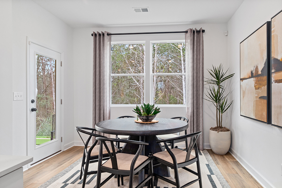 A dining room with a table and chairs.
