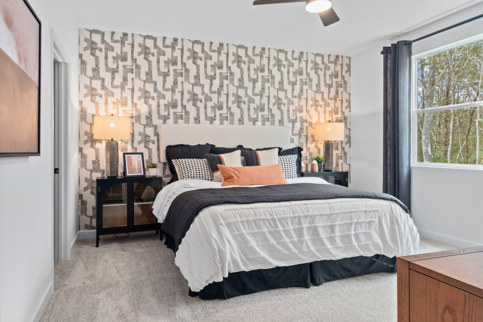 A bedroom with a bed and lamps.