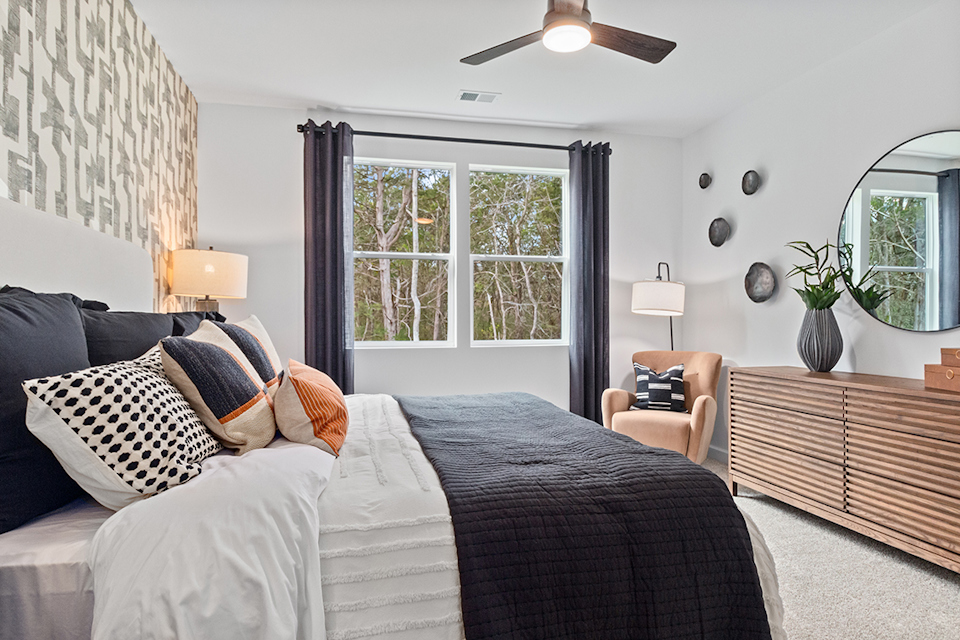 A bedroom with a bed and a fan.