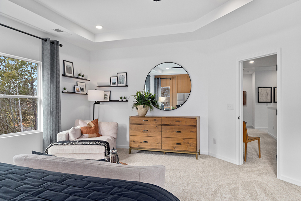 A bedroom with a mirror and a bed.