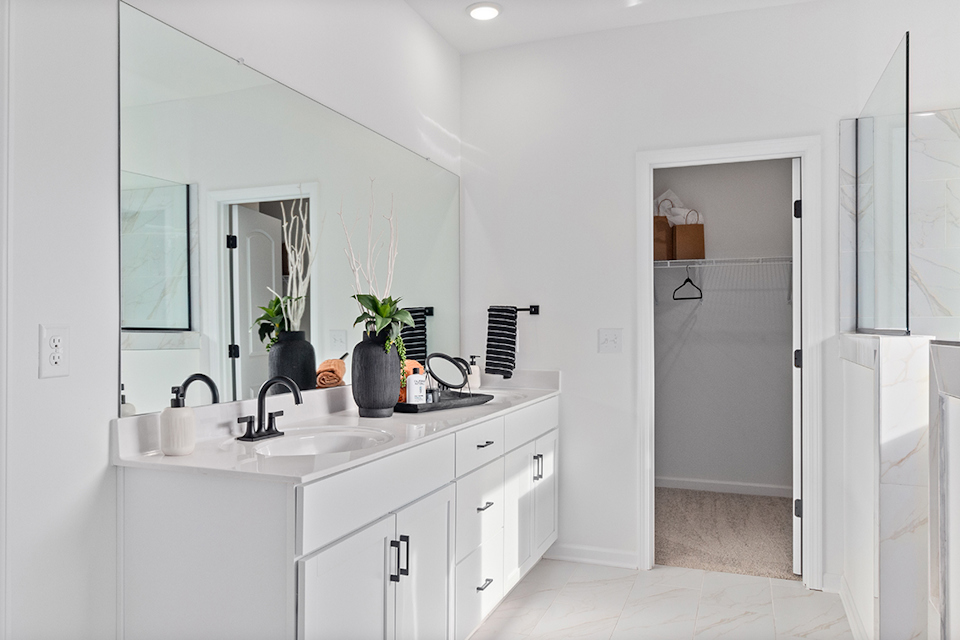 A bathroom with white cabinets.