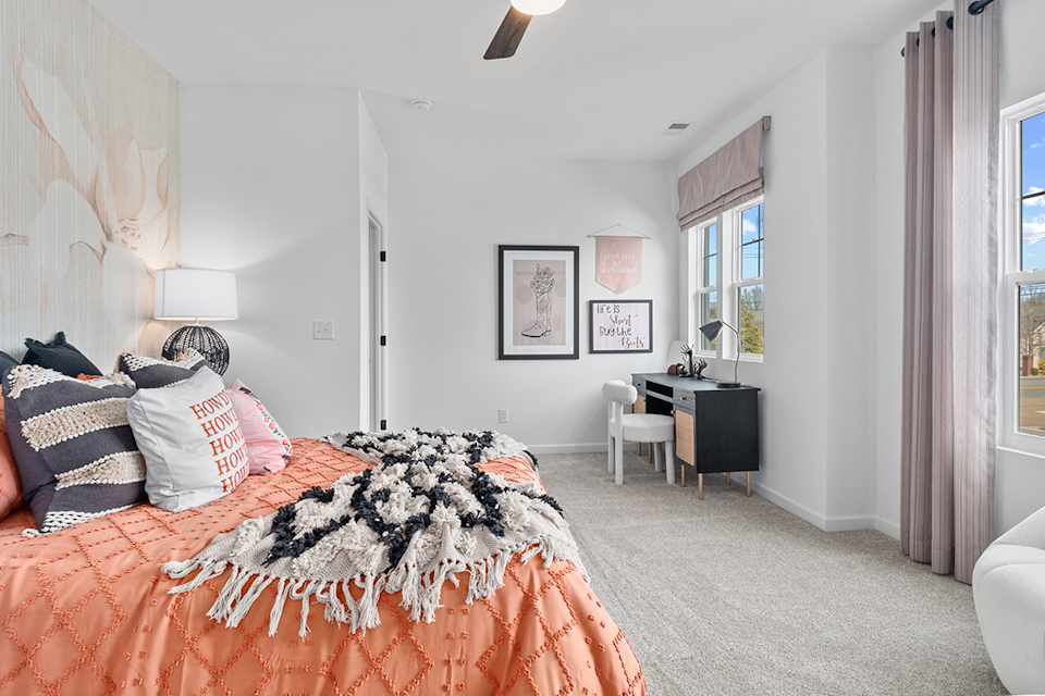 A bedroom with a bed and a desk.