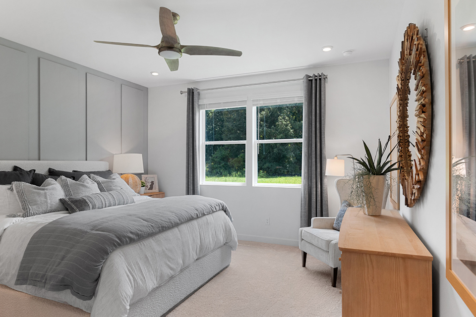 A bedroom with a bed and a fan.