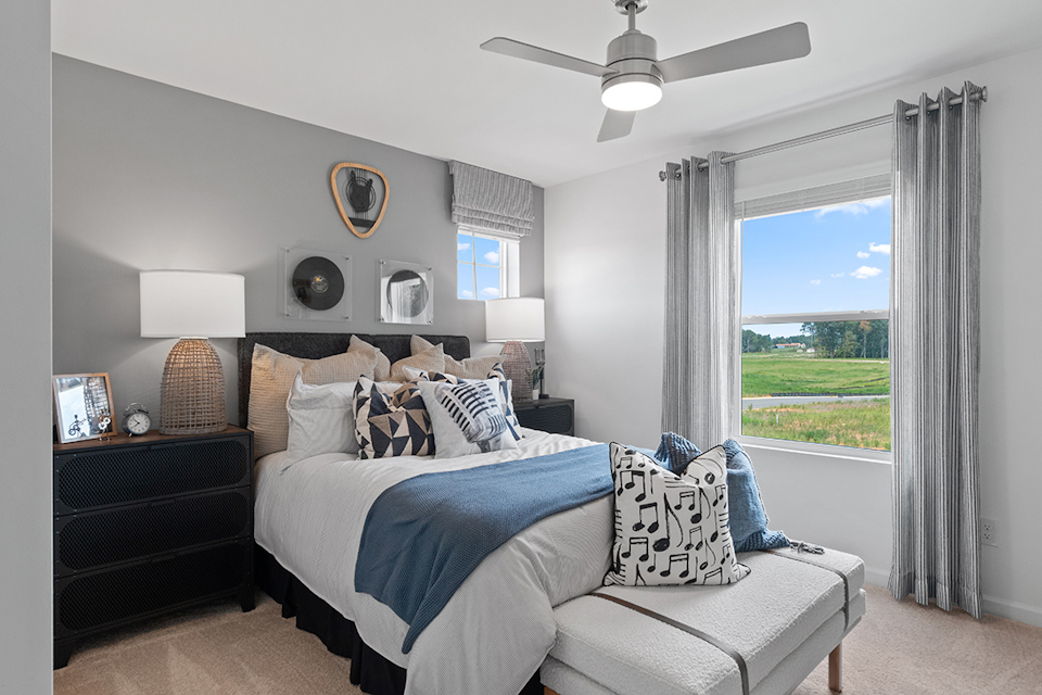 A bedroom with a large window.