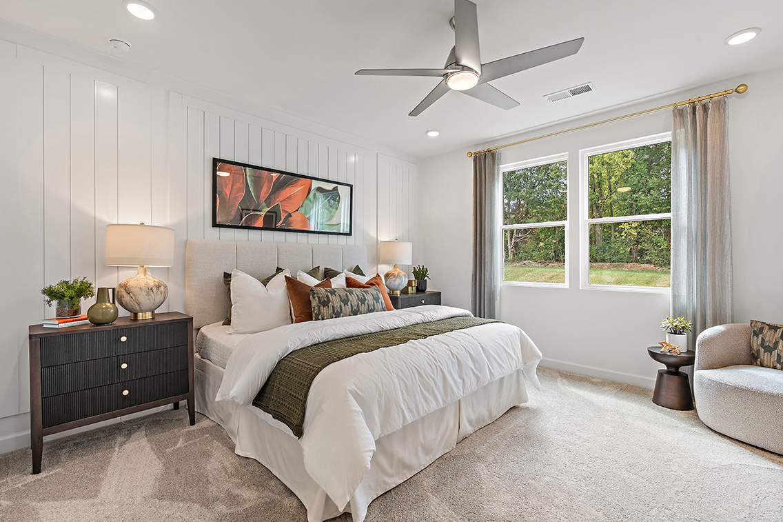 A bedroom with a bed and a fan.