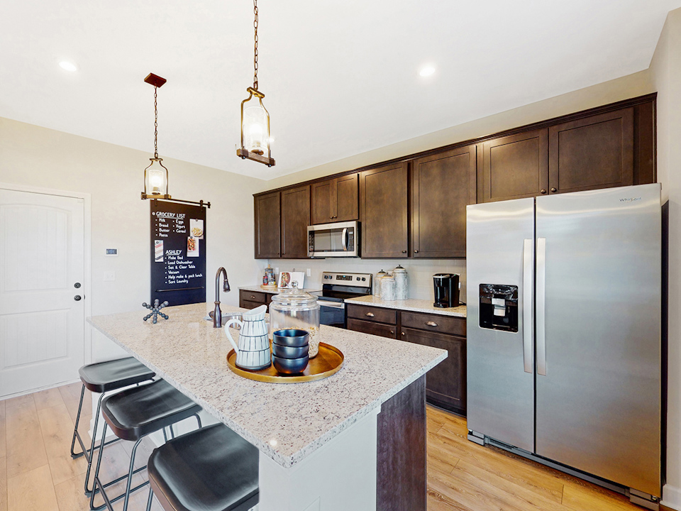 A kitchen with a bar and a refrigerator.