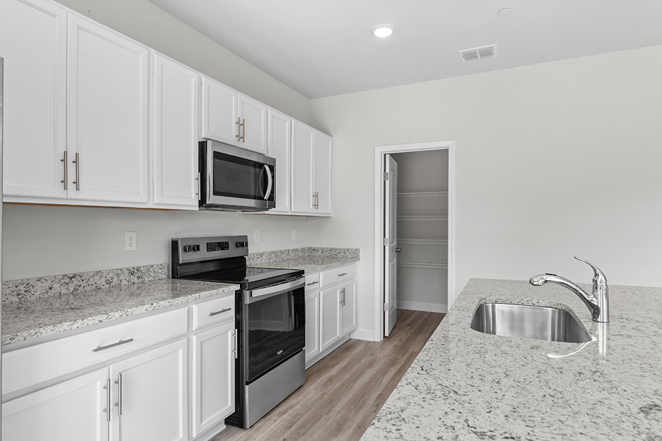 A kitchen with white cabinets.