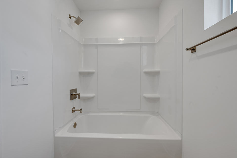 A white bathroom with a tub and sink.