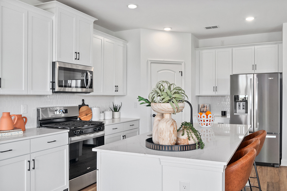 A kitchen with white cabinets.
