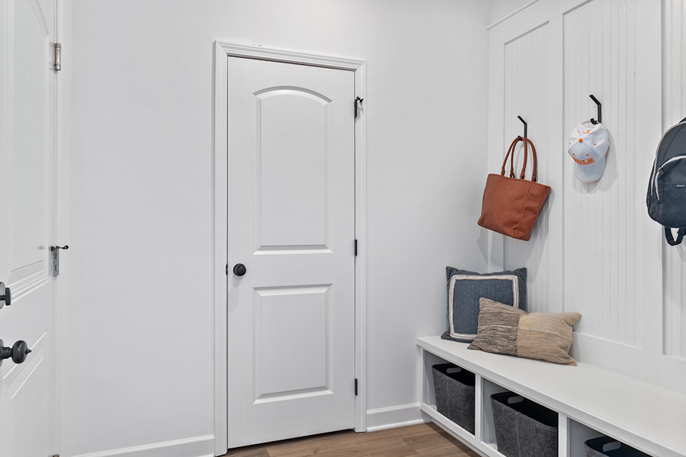 A room with white doors and a table with a basket and a basket.
