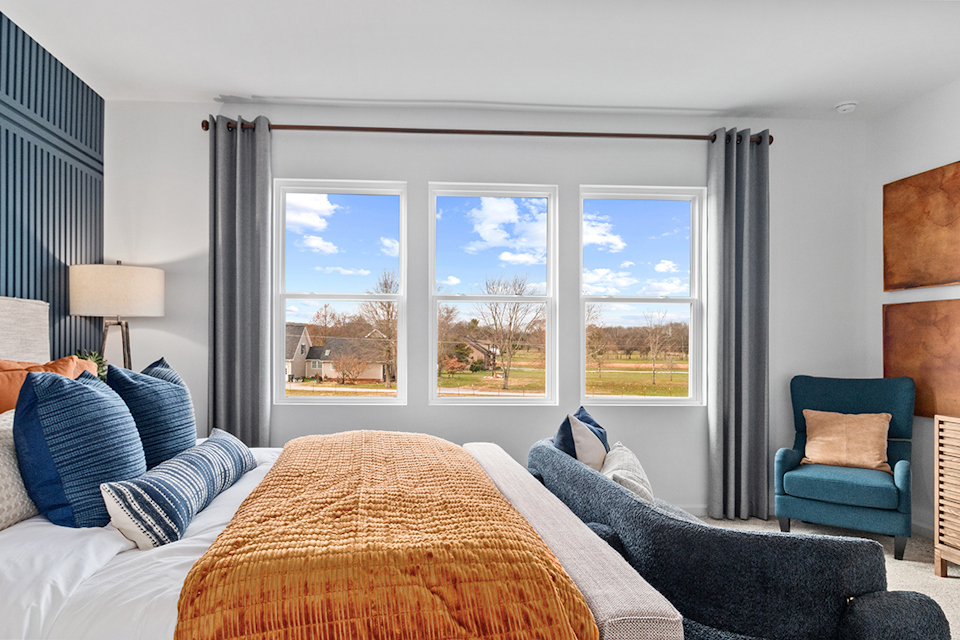 A bedroom with a large window.