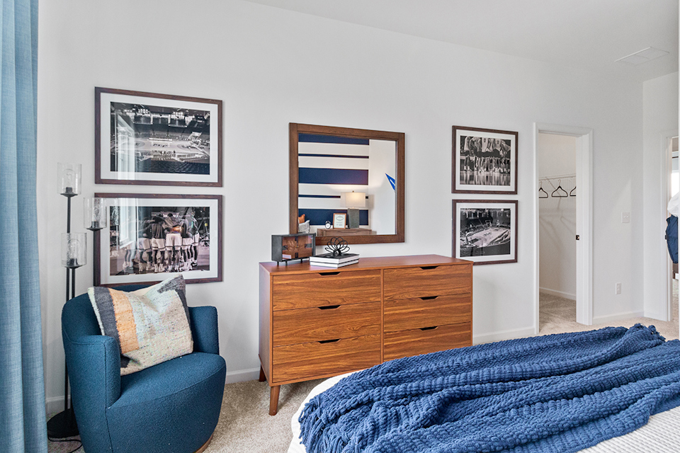 A bedroom with a bed and a chair.