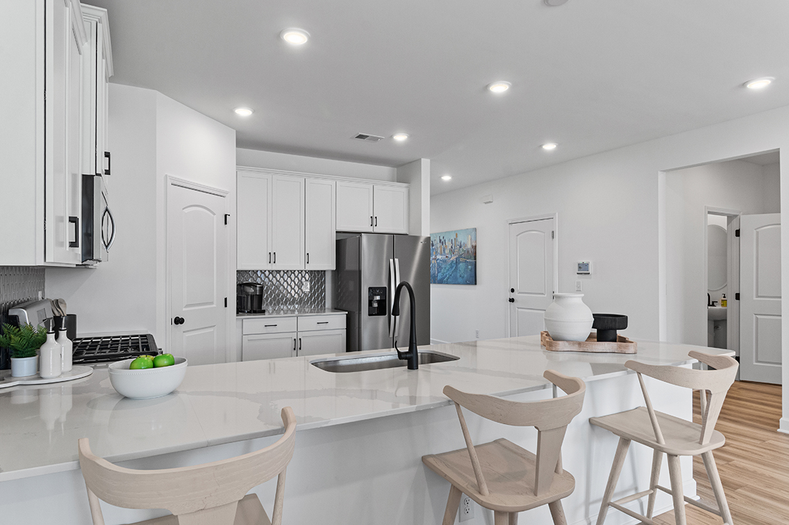 A kitchen with white cabinets.